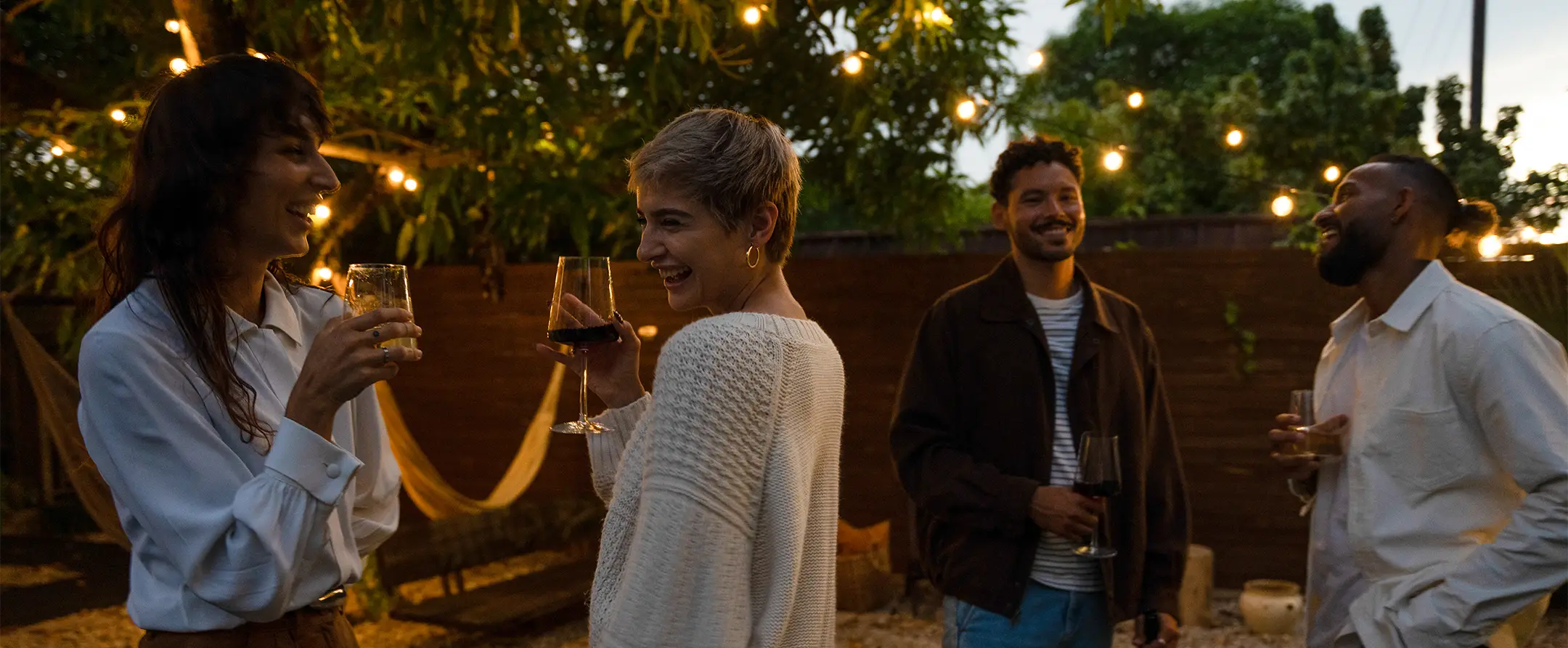 Four people drinking Bezel wines in a courtyard